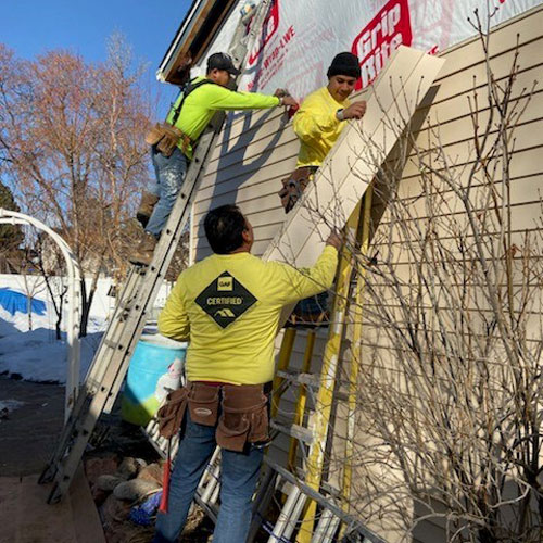 workers replacing siding
